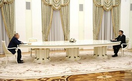 ７日の会談でテーブルを挟んで座る両首脳（ロシア大統領府提供）
